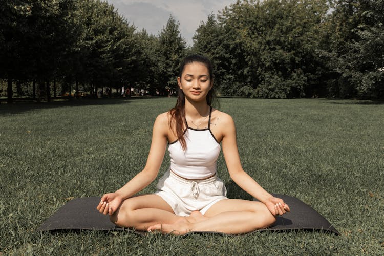 Charming Woman Doing Lotus Pose In Nature