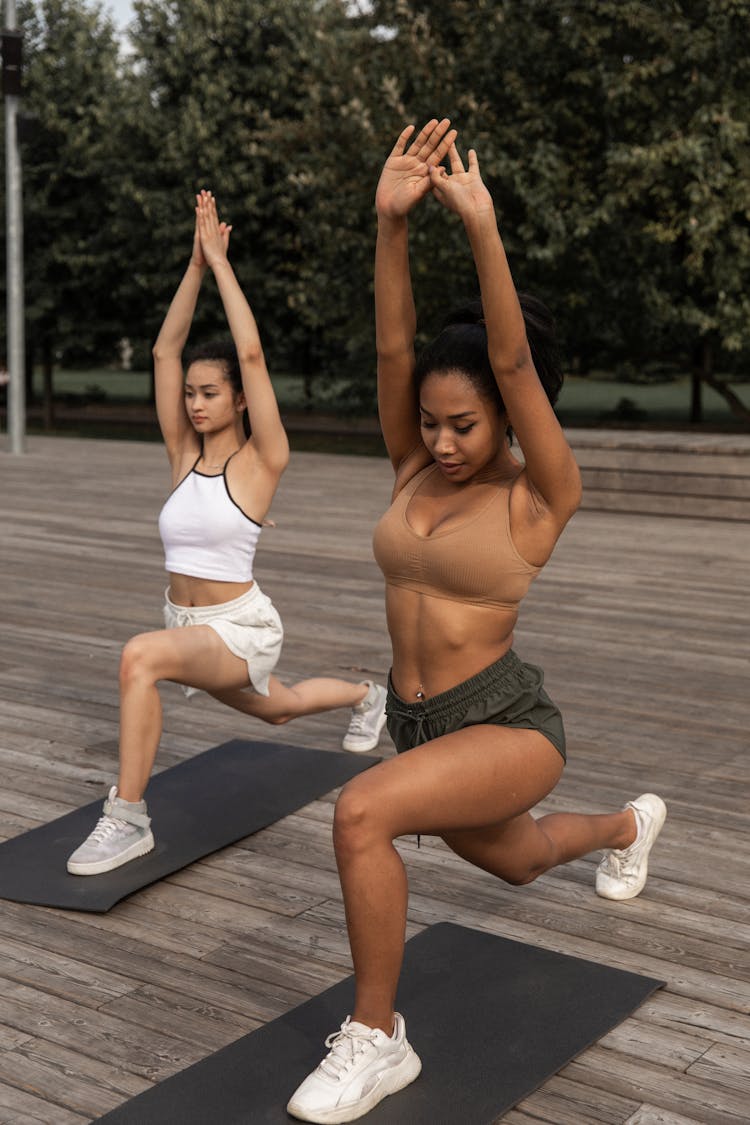 Diverse Women Doing Crescent Lunge Pose Together