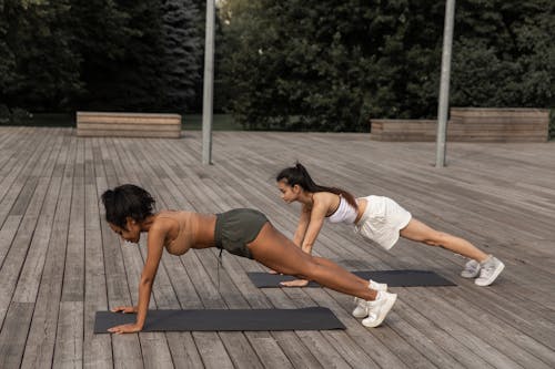 Concentrated multiracial women standing in plank position