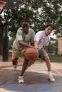 Confident multiracial players in sportswear competing for basketball ball while playing game on court
