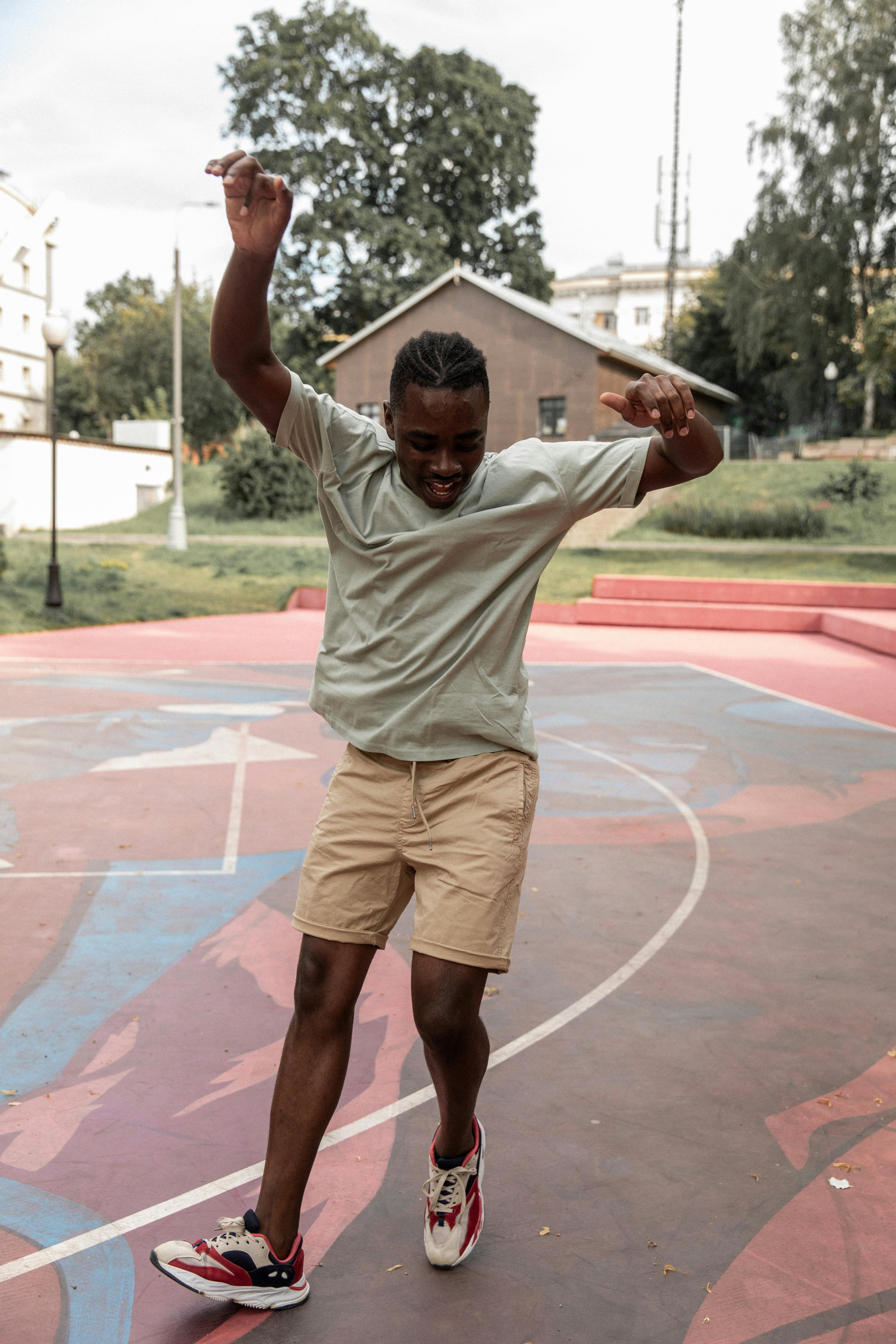 happy black man dancing happily on sports ground