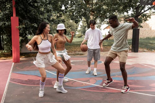 Free Delighted young diverse people dancing on sports ground Stock Photo