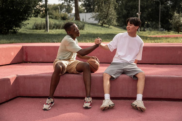 Fit Young Multiethnic Male Teenagers Shaking Hands After Basketball Training