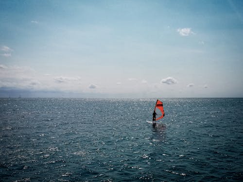 Person Windsurfing on a Blue Sea 