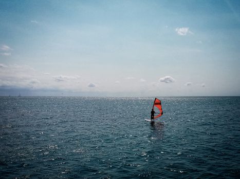 Person Windsurfing on a Blue Sea 