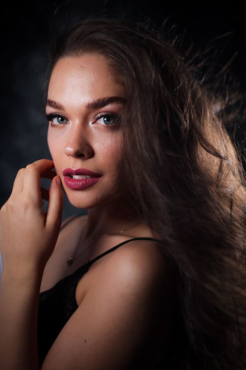 Free Captivating studio portrait of a woman with long hair and black top, exuding elegance. Stock Photo