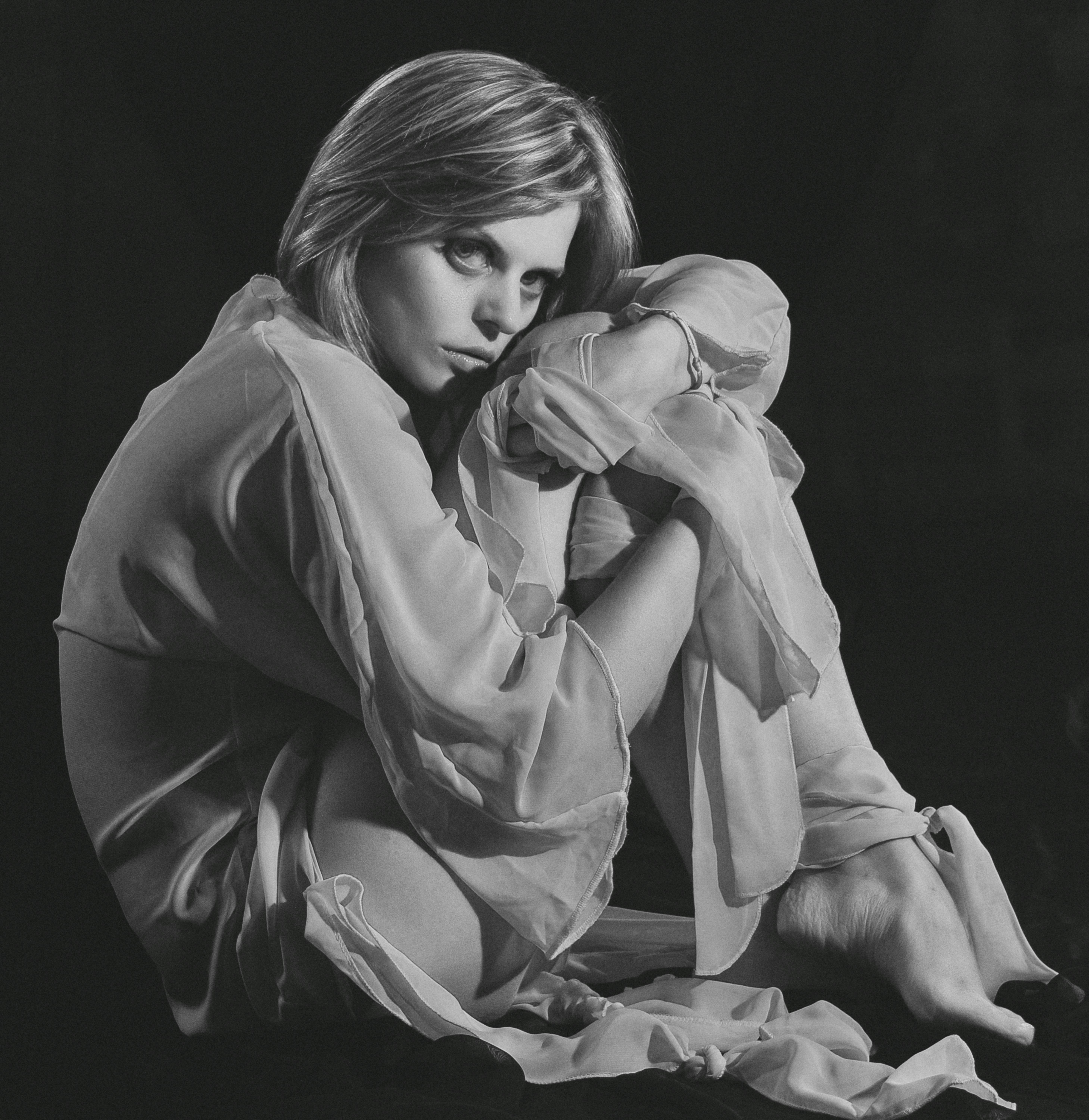 Studio portrait of a woman in a contemplative pose using grayscale tones.