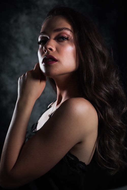 Free A dramatic studio portrait of a woman with rich, dark hair and a contemplative expression. Stock Photo