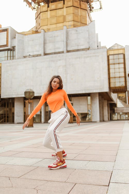 Woman Dancing Near the Concrete Building