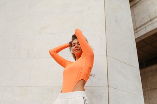 オレンジ色の長袖, ブルネット, ポージングの無料の写真素材
