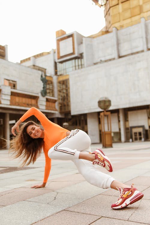 Woman Smiling While Balancing Herself on the Concrete Floor
