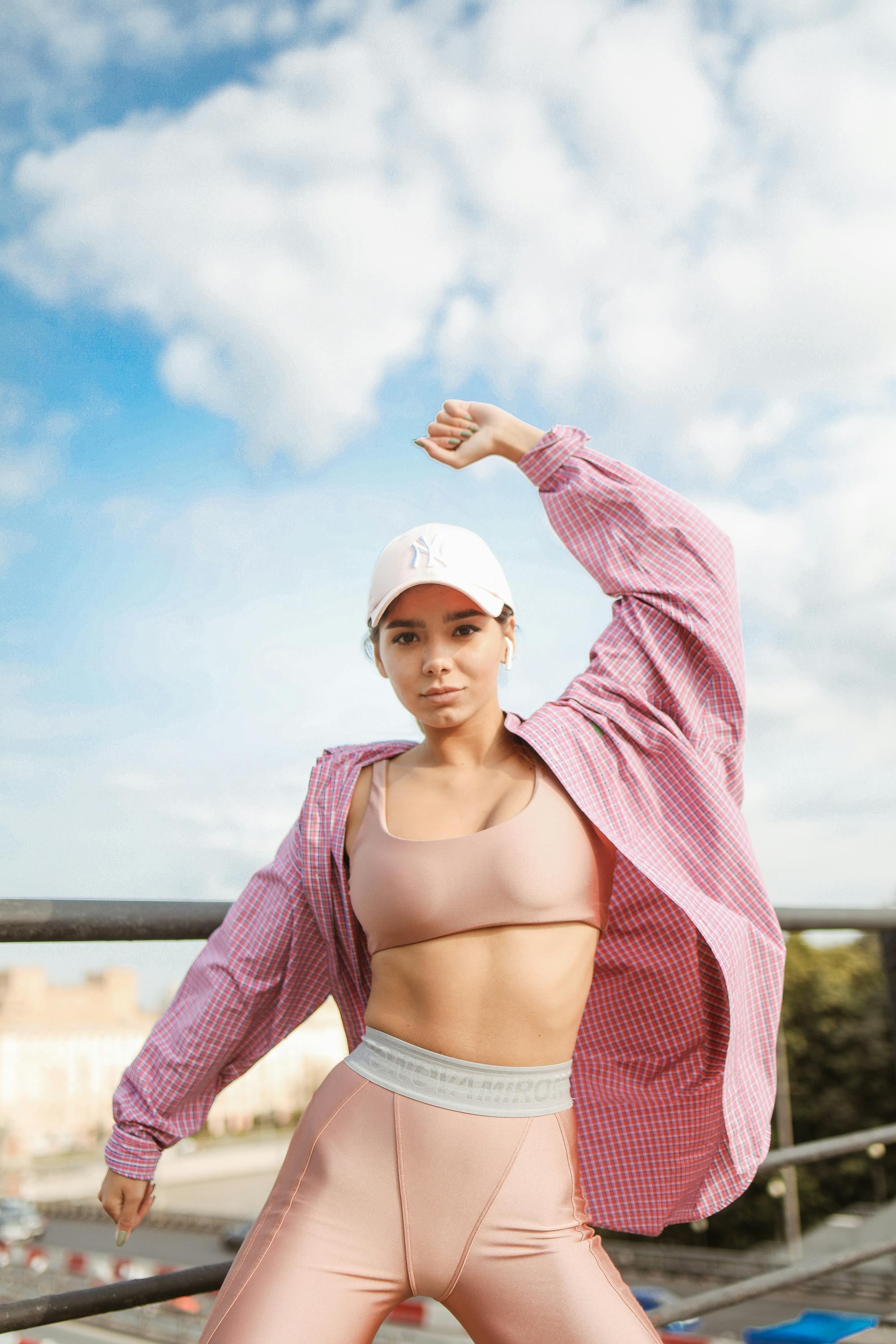 A Sexy Woman in Rose Gold Sports Bra and Rose Gold Cycling Shorts Posing ·  Free Stock Photo