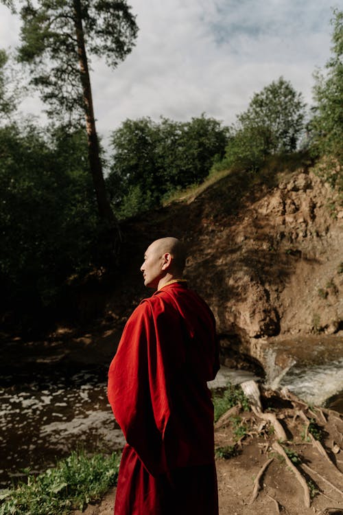 Back View of a Monk Standing Near the River 