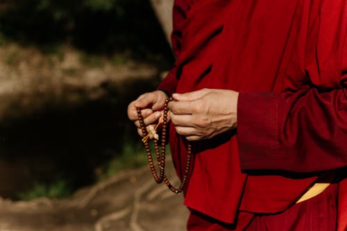 Monk Holding a Necklace