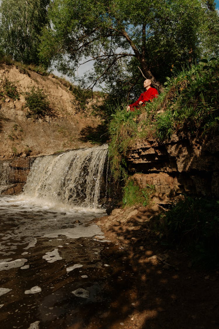 Monk During Meditation Over River In Summer