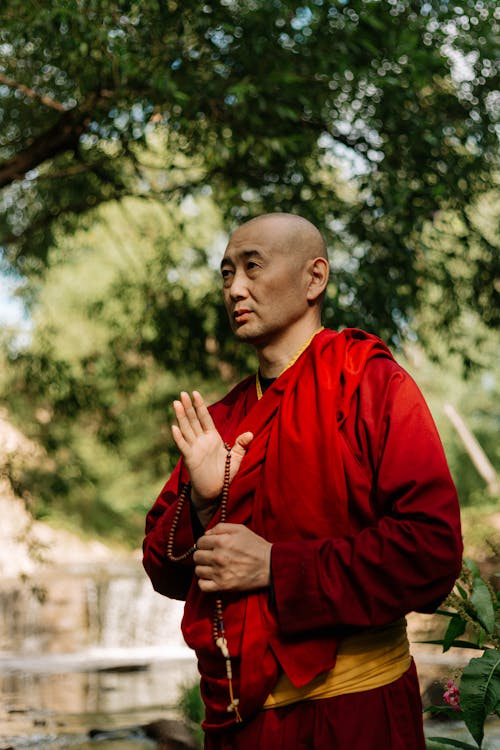 Man in Red Long Sleeve Shirt Standing Near Green Trees