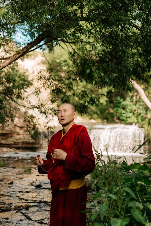 Tibetan Buddhist Monk Praying on Beads by River