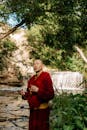 Tibetan Buddhist Monk Praying on Beads by River