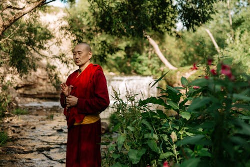 A Monk Standing while Praying Outdoors 