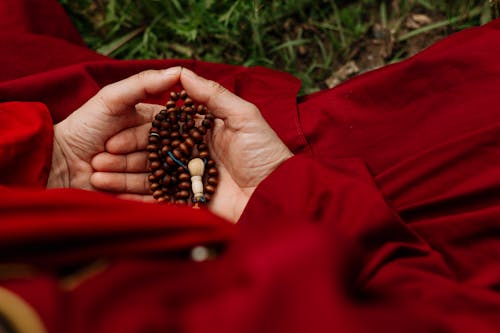 Free Person Holding Red and Black Beads Stock Photo