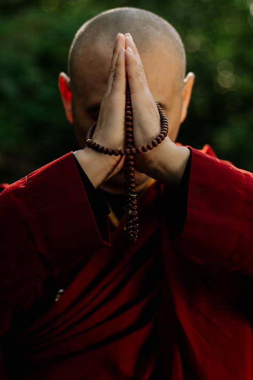 Monk with Clasped Hands Praying on Beads