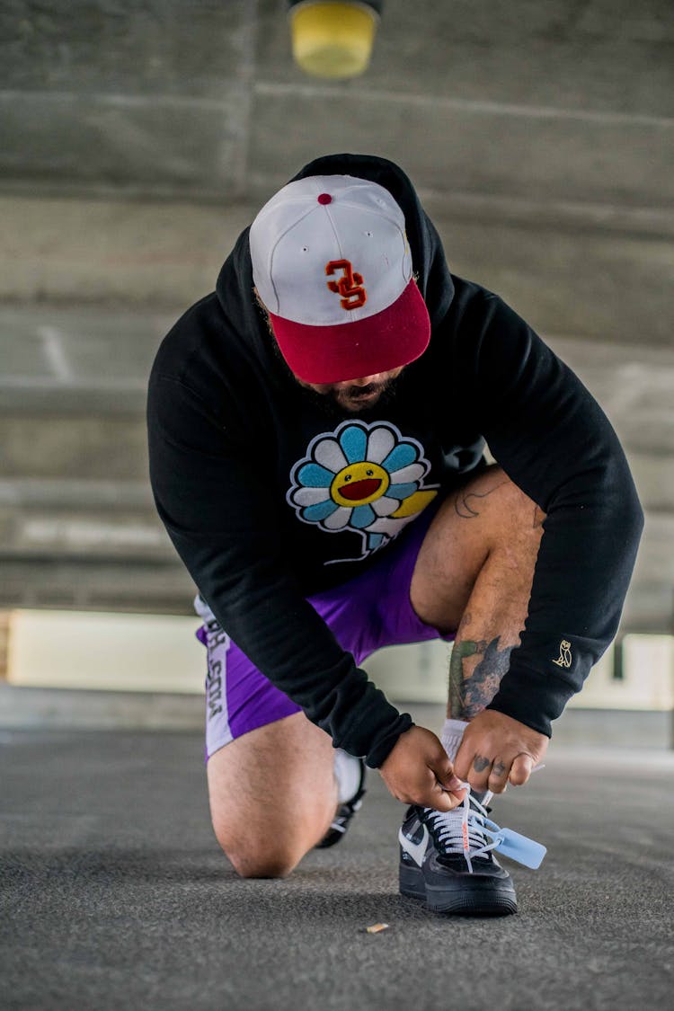 Unrecognizable Hipster Man Tying Shoelaces On Sneakers