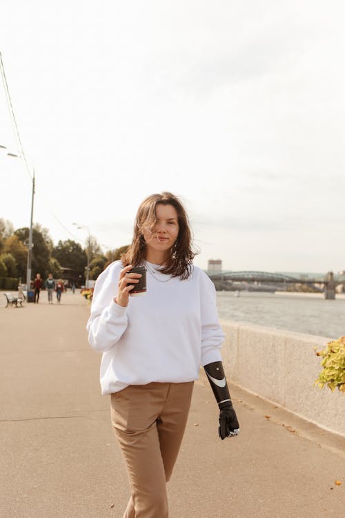 Woman Walking and Holding a Paper Coffee Cup