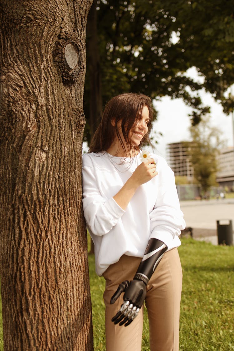 Woman With A Prosthetic Hand Holding A Flower