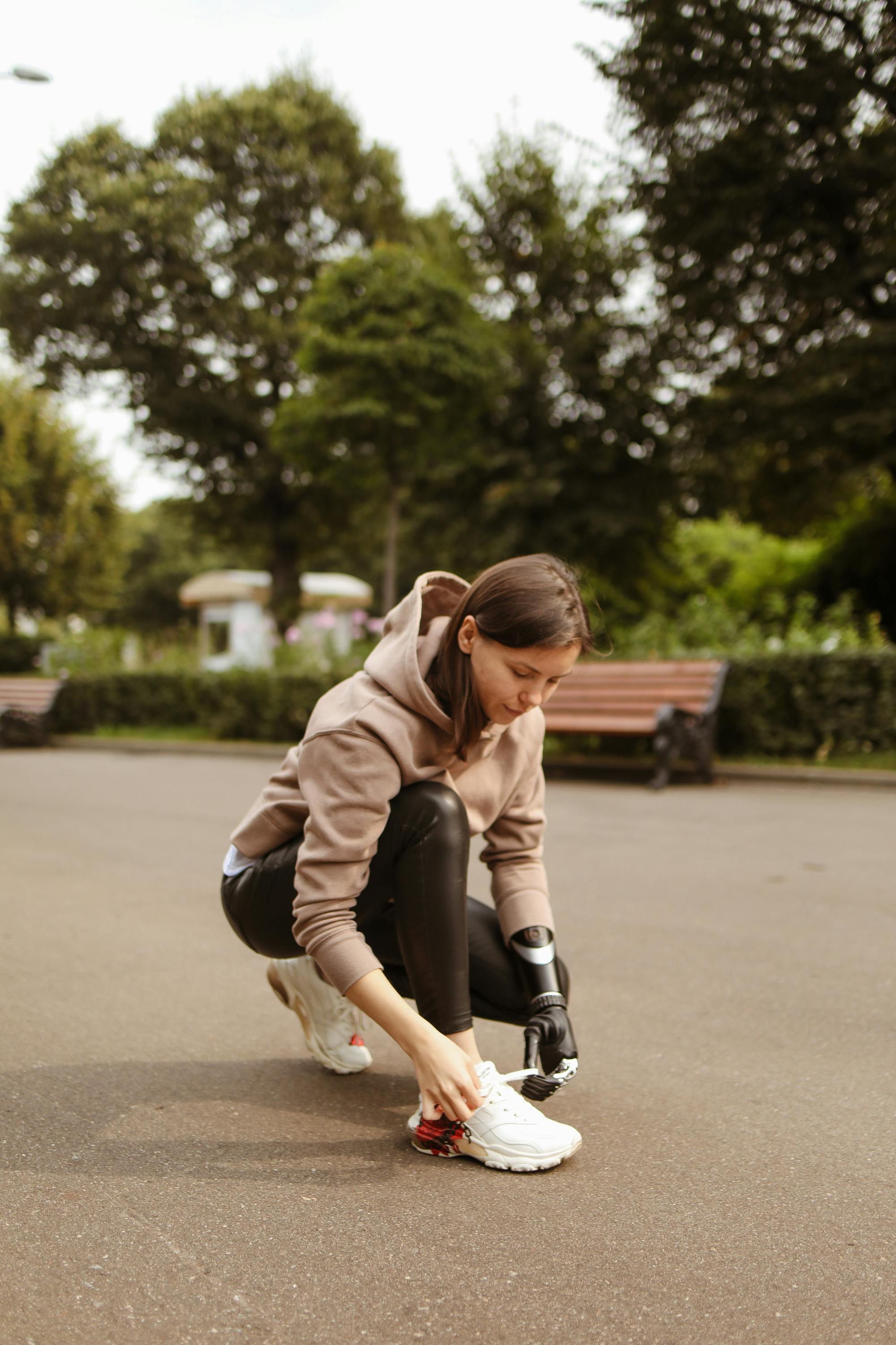 woman with prosthetic hand tying her shoelaces