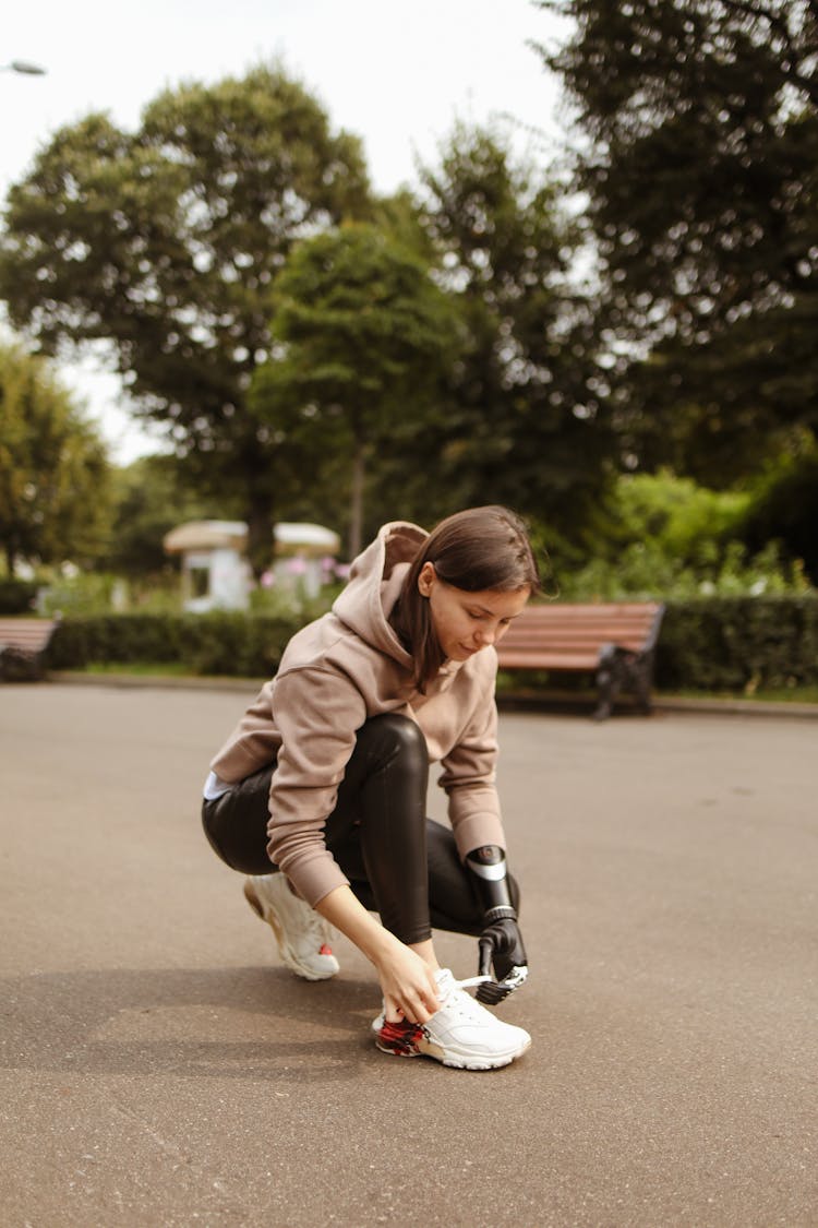 Woman With Prosthetic Hand Tying Her Shoelaces