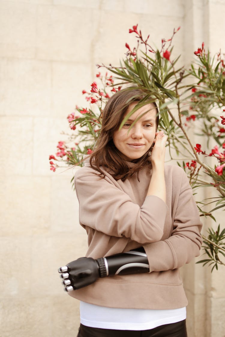 Brunette Woman In Sweatshirt Posing By Flowers