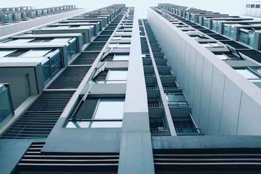 低角度镜头下的现代摩天大楼，采用光滑的玻璃面板和钢结构