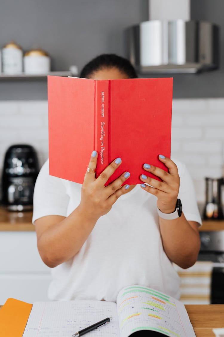 Woman Reading Book In Kitchen