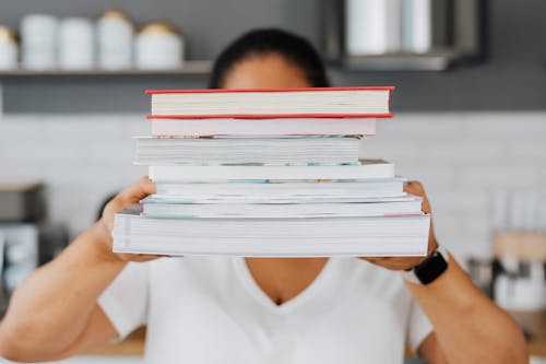 A Person Holding a Stack of Books