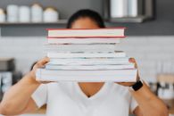 Man in White V Neck T-shirt Holding Books