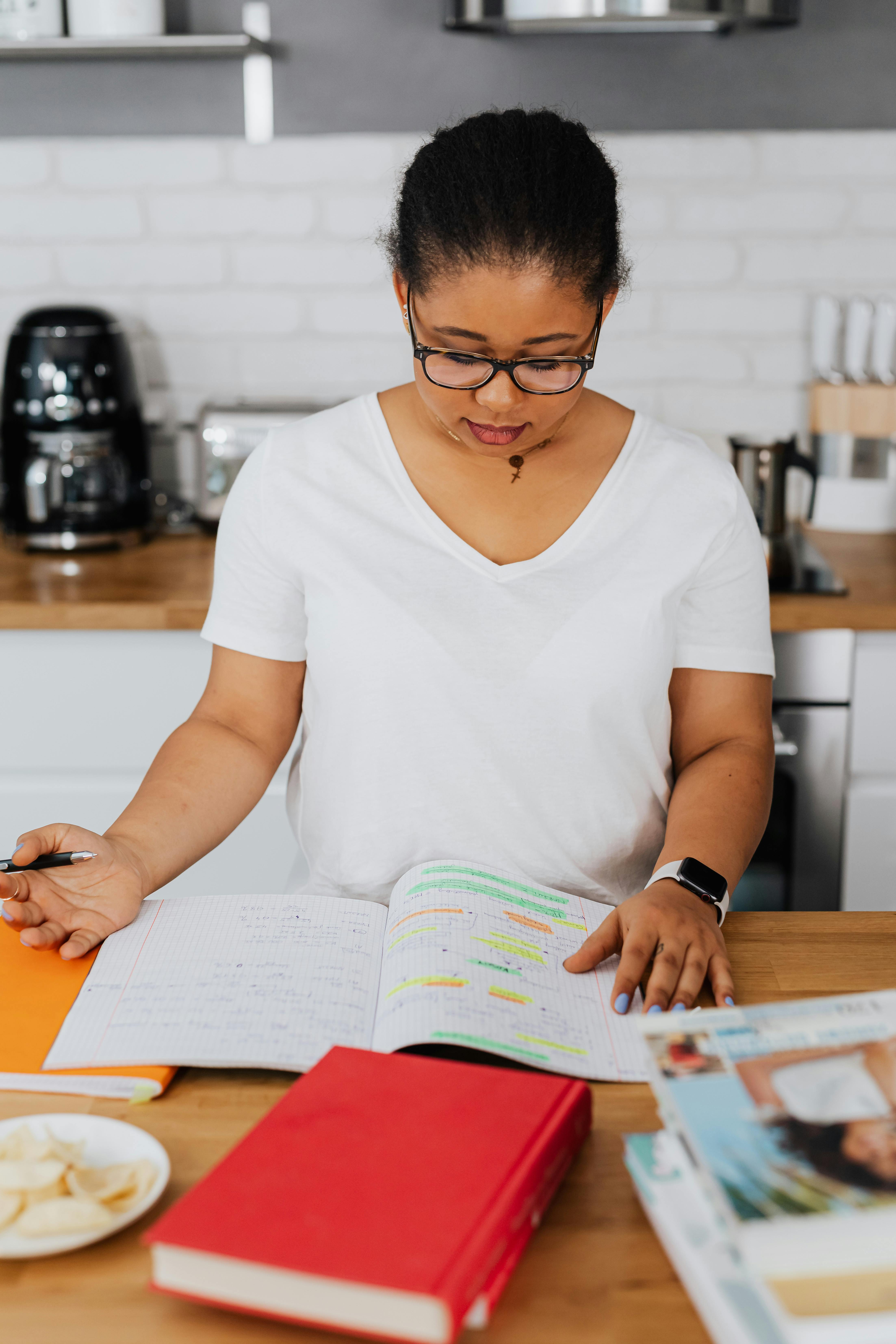 一位成年妇女在当代厨房环境中阅读书籍，研究内容