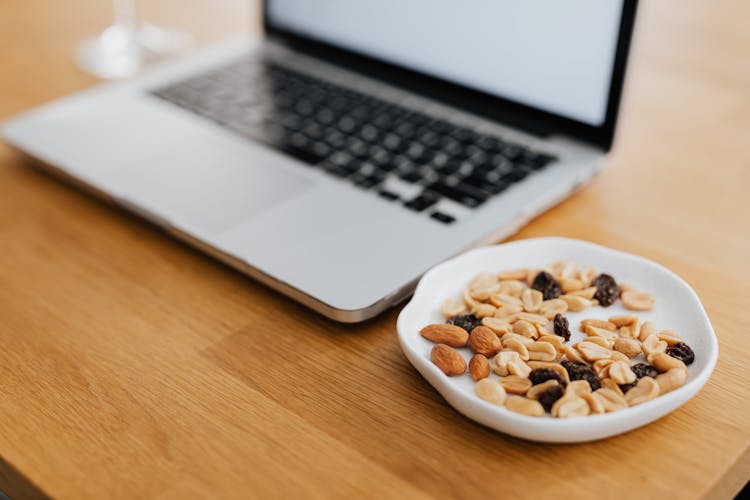 Nuts And Raisins For Healthy Snack By Laptop