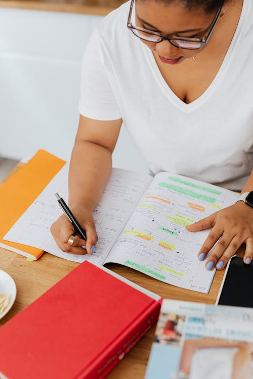 Free Woman Writing in Notebook Stock Photo