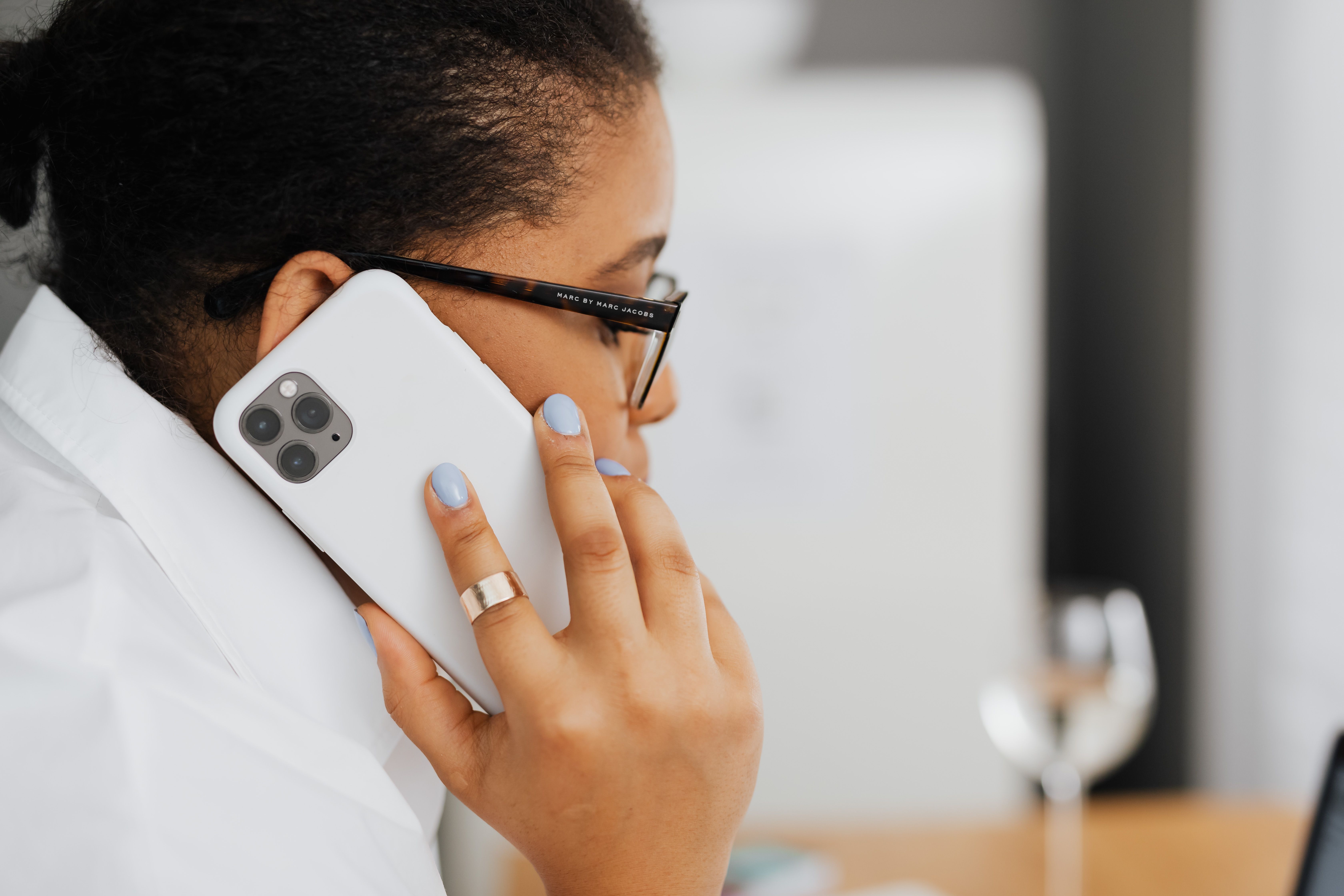 Black woman speaking on a smartphone in a work setting