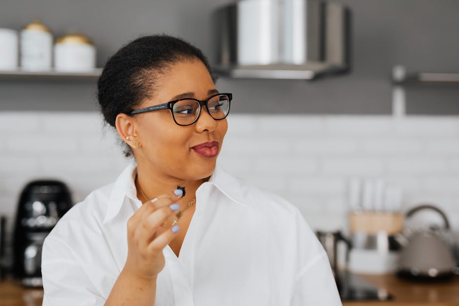 country style adult day care - Close-up of an adult woman with glasses in a modern kitchen, looking sideways with a smile.