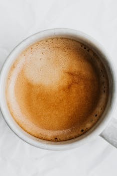 Artistic top view of a steaming cup of coffee with rich, creamy foam, perfect for morning energy.