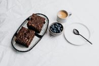 Sliced Chocolate Cake on White Ceramic Plate Beside Stainless Steel Spoon