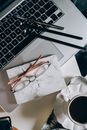 工作区的顶视图展示了笔记本电脑、眼镜和咖啡杯的艺术性摆放