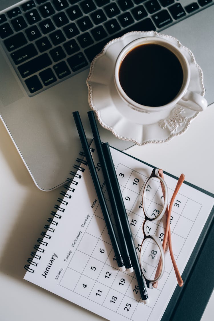 Cup Of Black Coffee Beside A Calendar