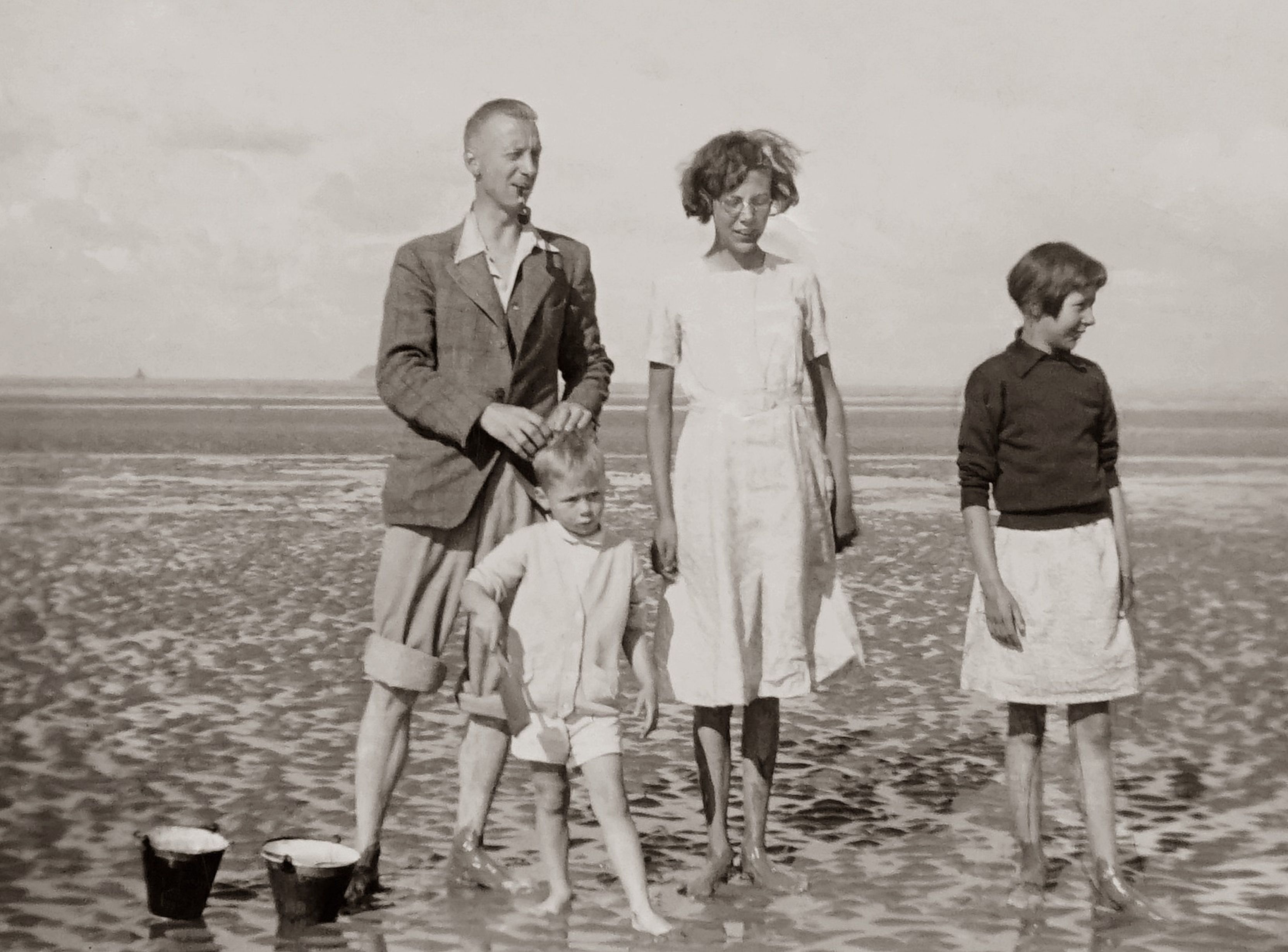 Classic family portrait on a beach, evoking timeless summer memories and togetherness.