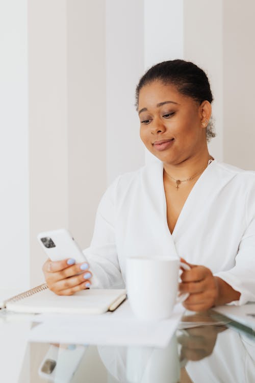 Woman in White Top Using a Cellphone