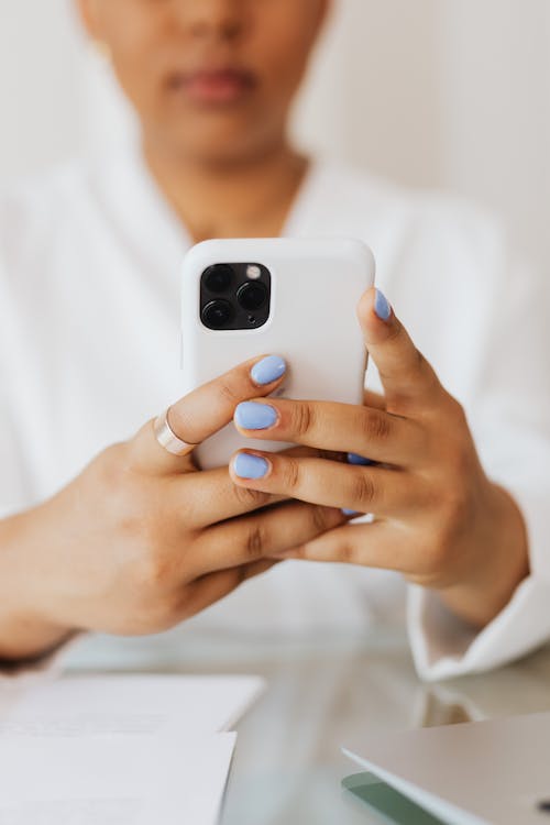 Free Person in White Top Using a Cellphone  Stock Photo
