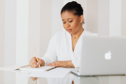 Woman in White Blazer Writing on White Paper
