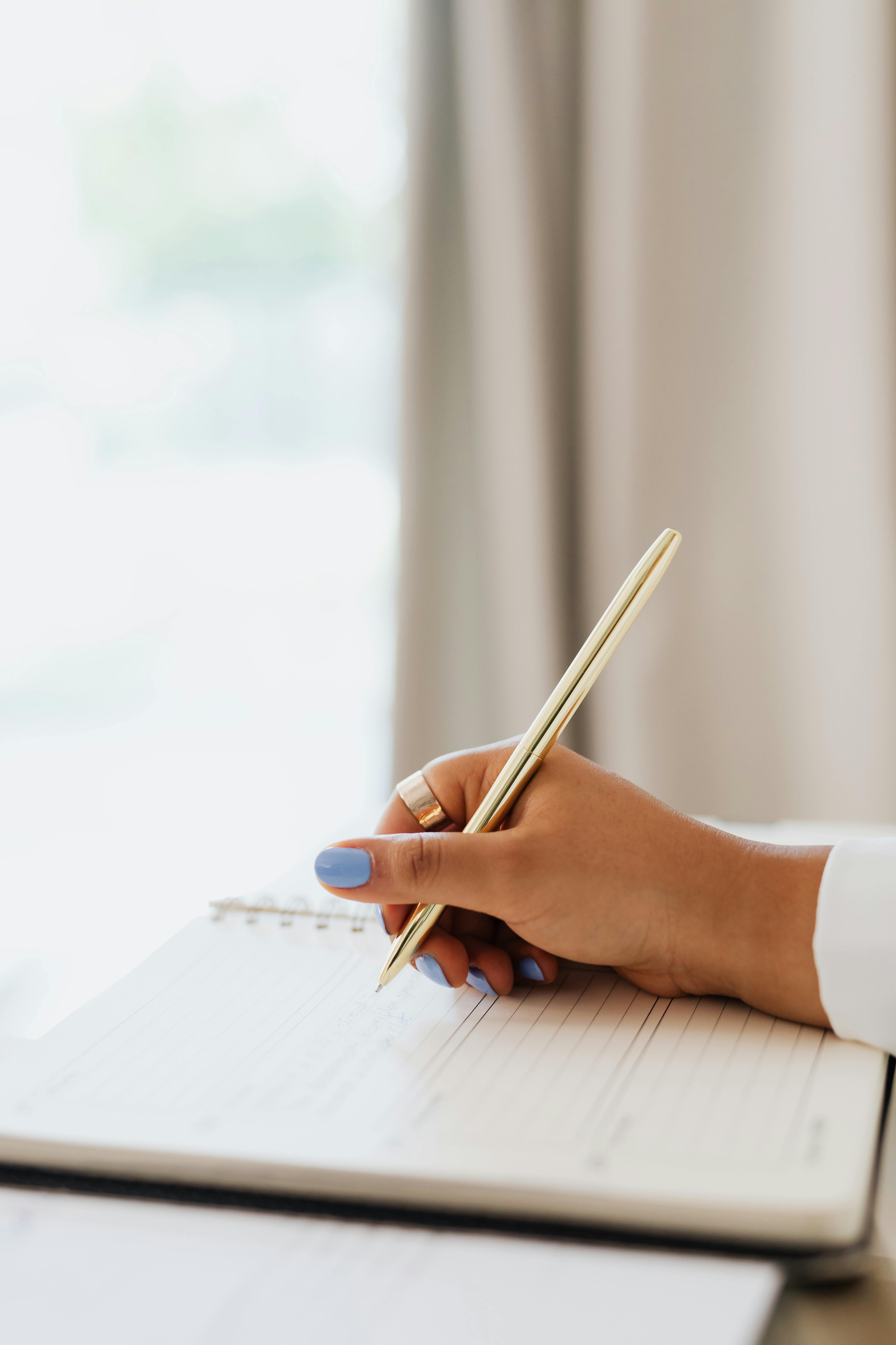 Person Writing On Notebook · Free Stock Photo