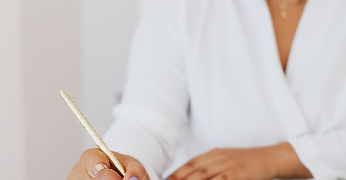 Woman in White Top Writing on a Notebook · Free Stock Photo